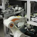 Fertigungsanlage Duschensifon von nahem, durchsichtige Kabel, weißer Roboterarm