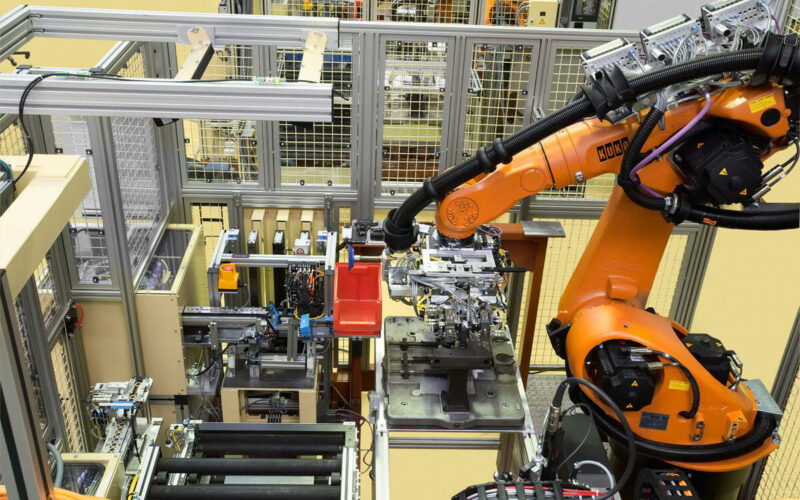 Potideckelmontage, orangener Roboterarm in der Anlage von oben