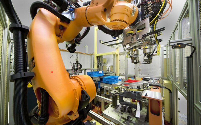 Potideckelmontage, orangener Roboterarm in der Anlage