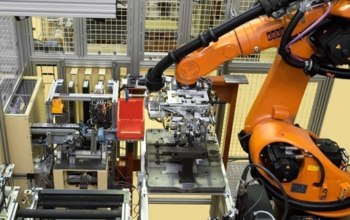 Robotermontage mit „Griff in die Kiste“, orangener Roboterarm in einer Anlage