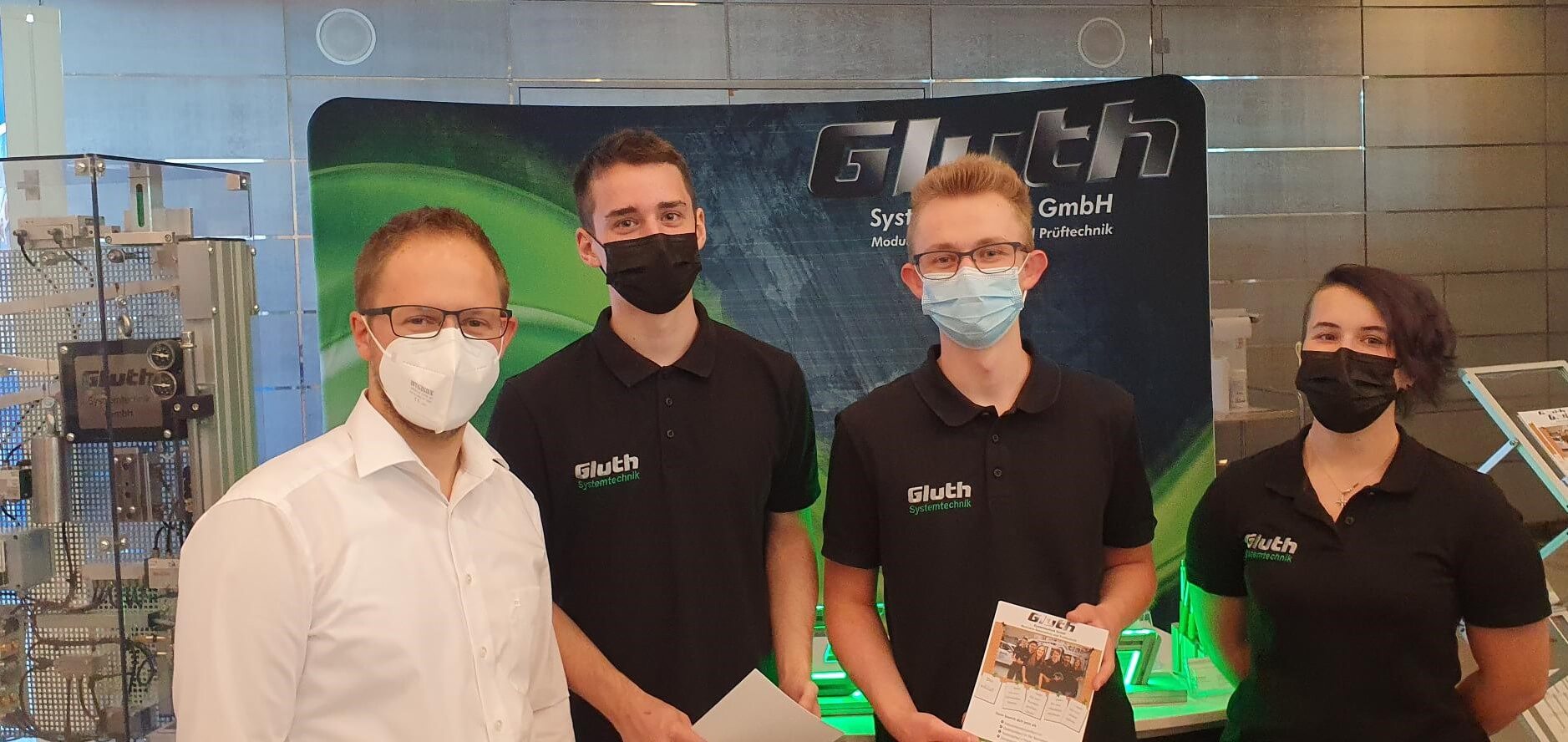 Ausbildungsmesse 2021, Mitarbeiter der Firma Gluth in Masken stehen vor dem Messestand
